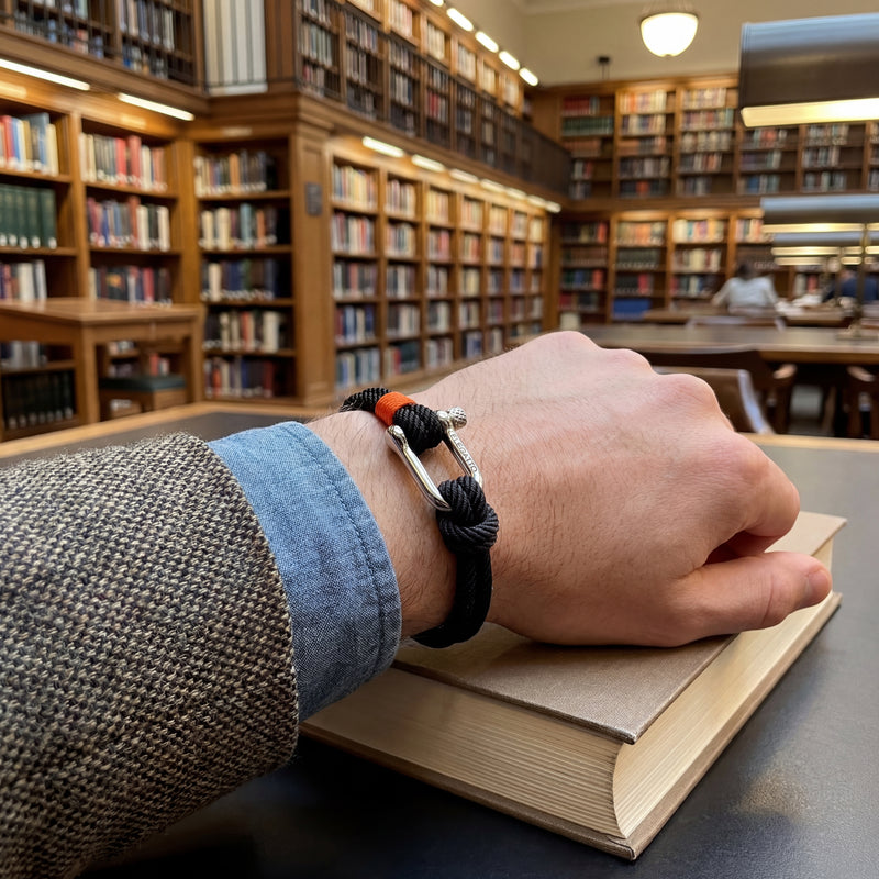 Hand with a bracelet on a book in a library setting