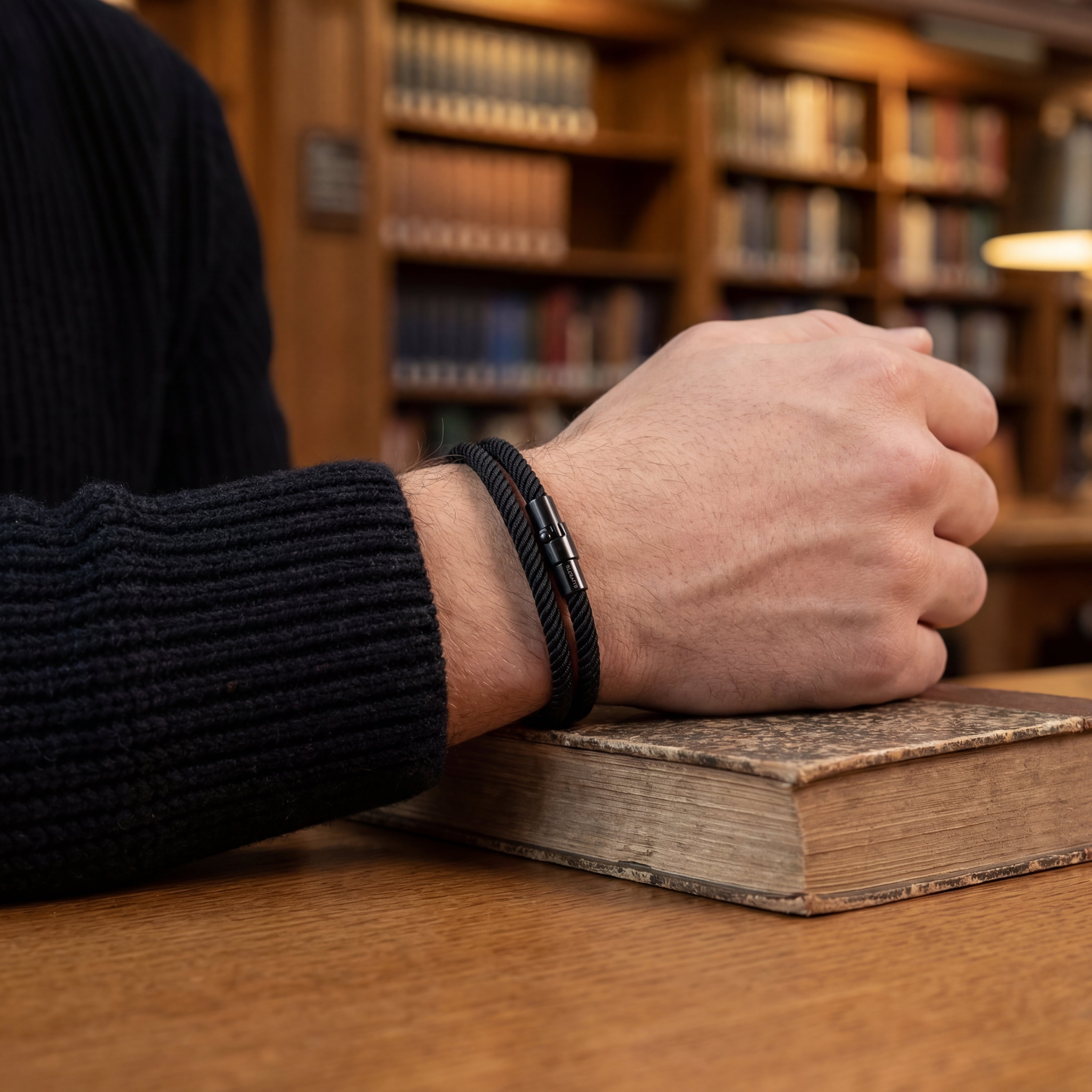 Hand resting on an old book in a library setting